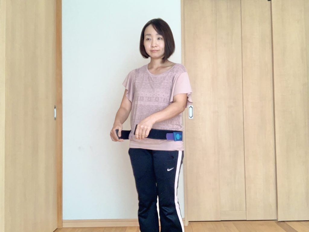 後ろから前にベルトを締める